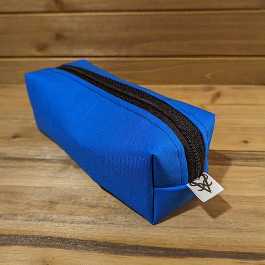 The Bag of Devouring in blue showing the square side with the Aras Sivad Studio logo on the end.