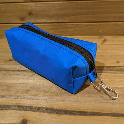A view of the blue Bag of Devouring with a black zipper down the middle and a keychain clip at the top.