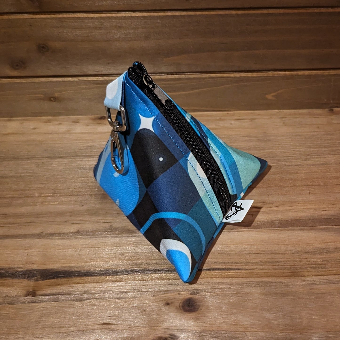 A D4 bag with blue toned rockets flying through tonal squares around planets and stars.