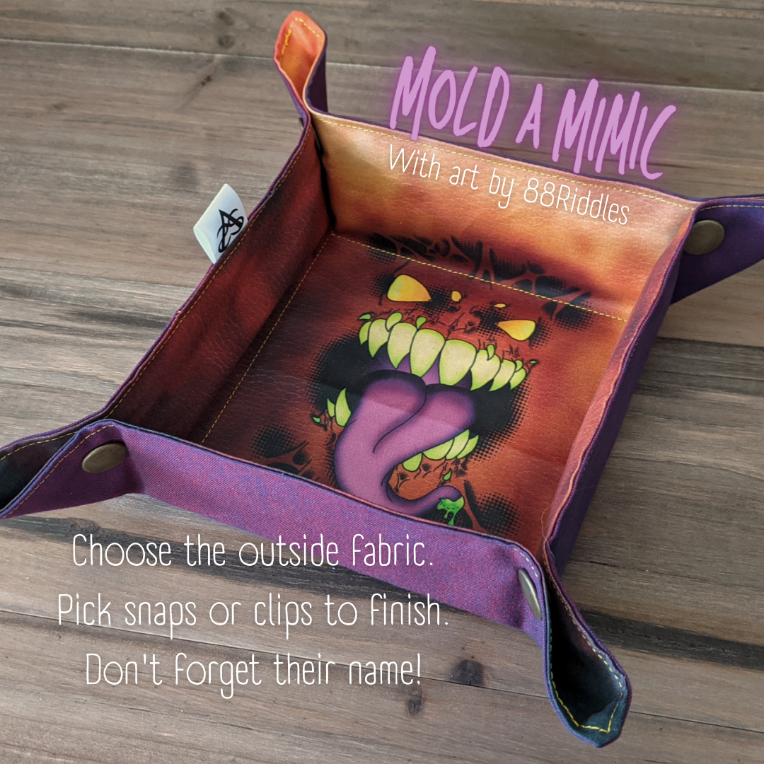 A dice tray with blue/purple/red fabric outside and a mimic face print in the center sits on a wood surface with brass snaps in the corners. Text says, "Mold a Mimic with art by 88 Riddles. Choose the outside fabric. Pick snaps or clips to finish. Don't forget their name!"
