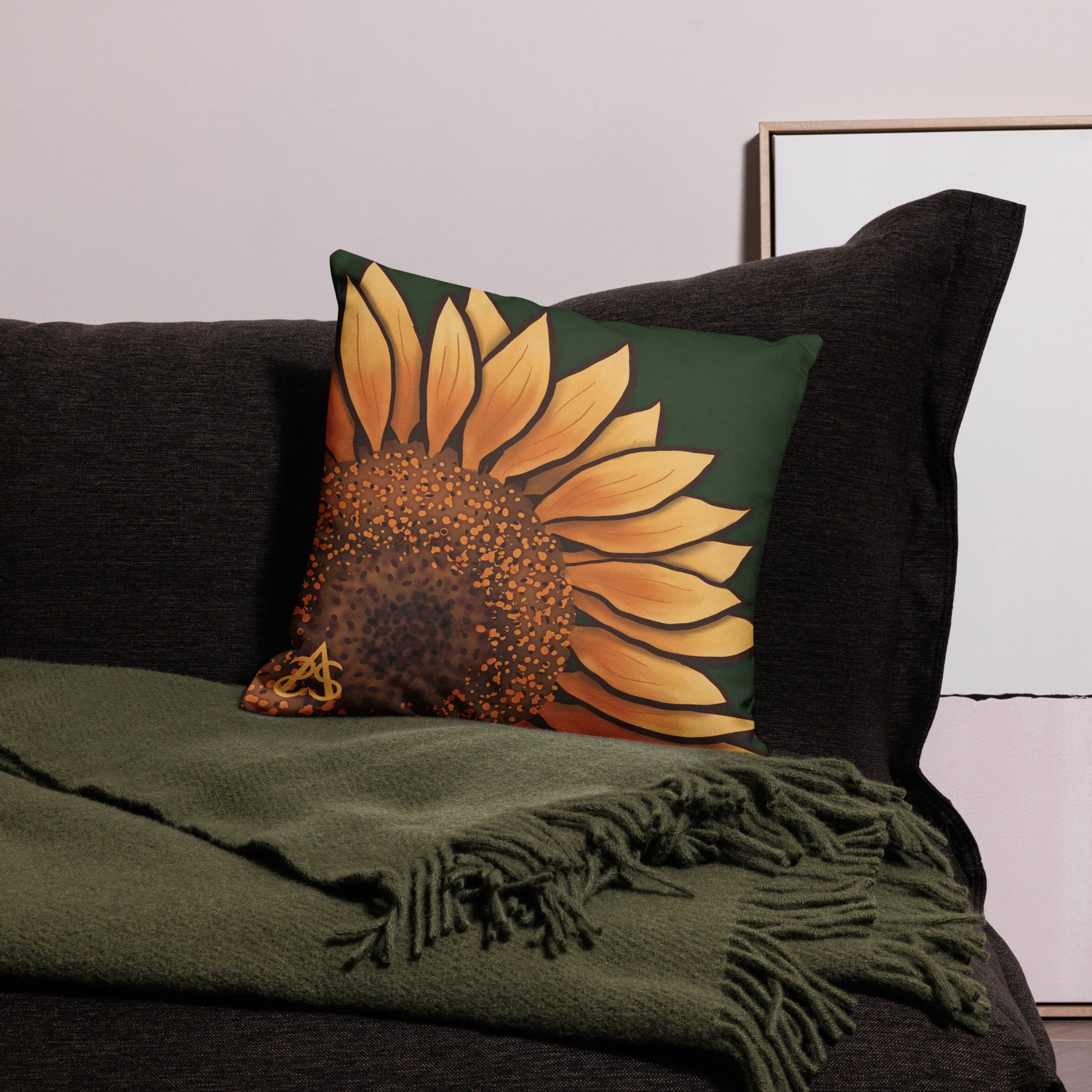 A medium sized square pillow with a hand painted sunflower by Aras Sivad on a dark green background.