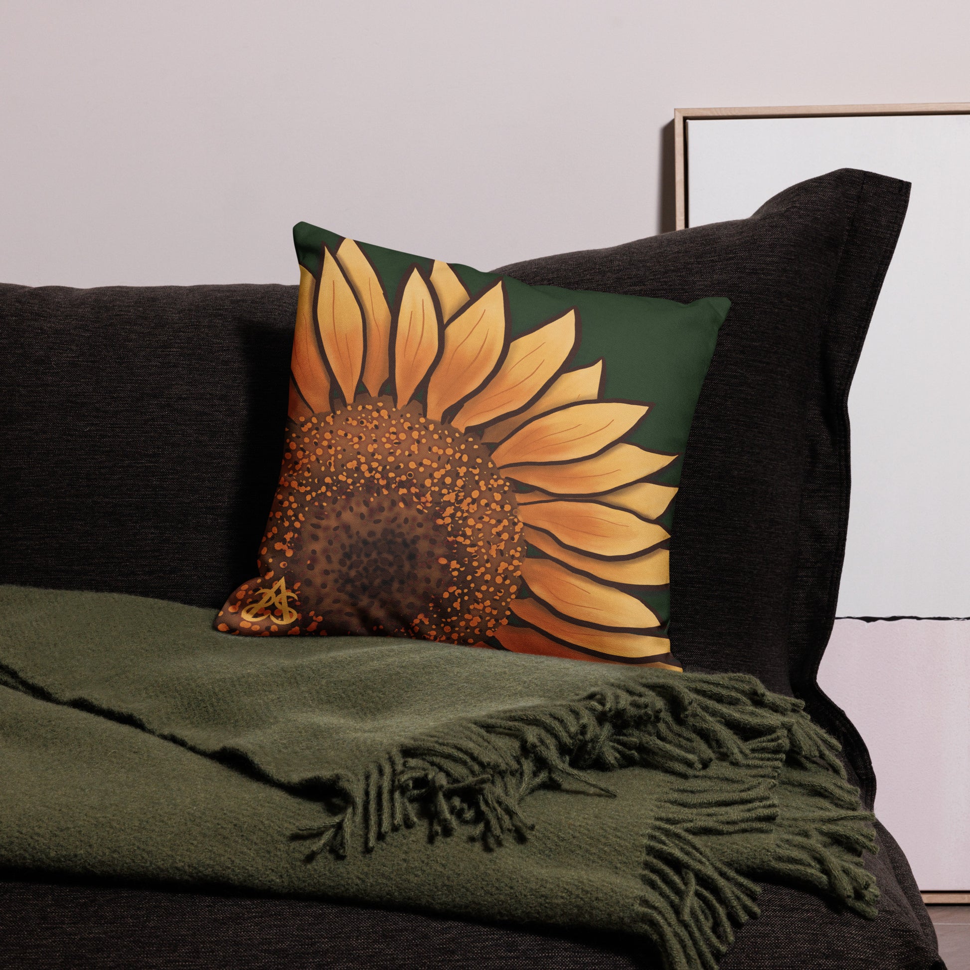 A medium sized square pillow with a hand painted sunflower by Aras Sivad on a dark green background.