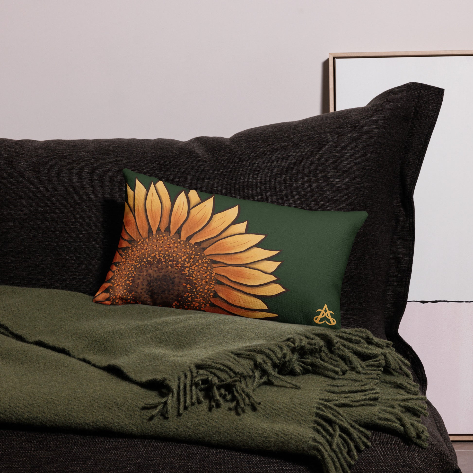 A lumbar pillow with a hand painted sunflower by Aras Sivad on a dark green background.