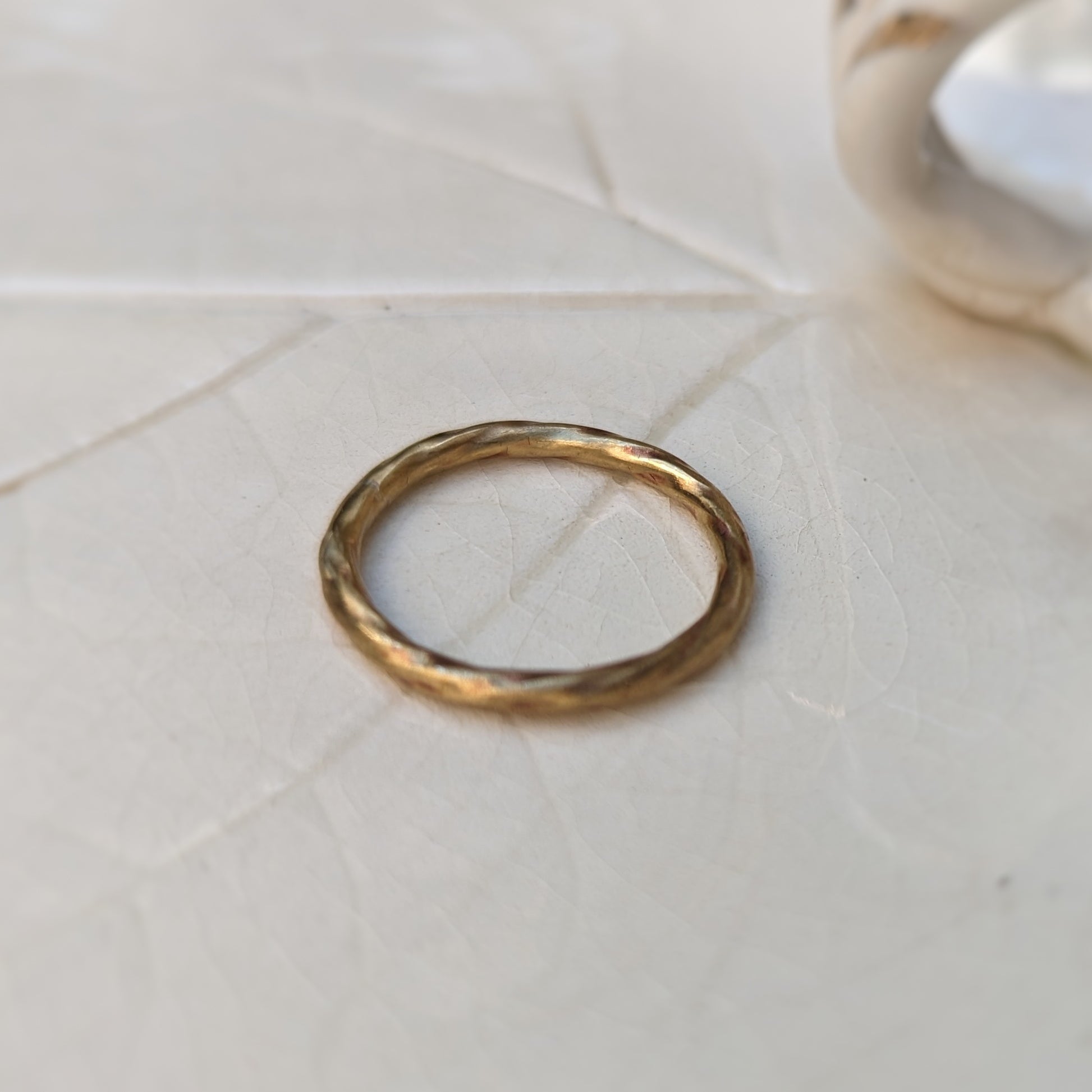 A brass ring with a subtle twist texture.