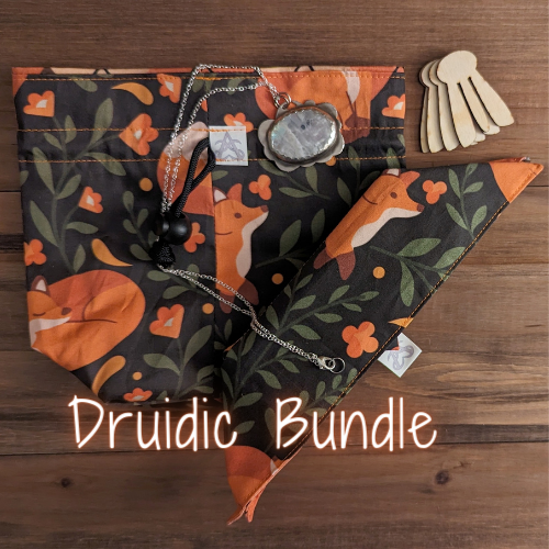 A fox and floral drawstring bag with argyle liner, matching pocket tray with wood clips, and a silver cloud necklace with a large oval moonstone and Druidic Bundle written in glowing orange handwriting.