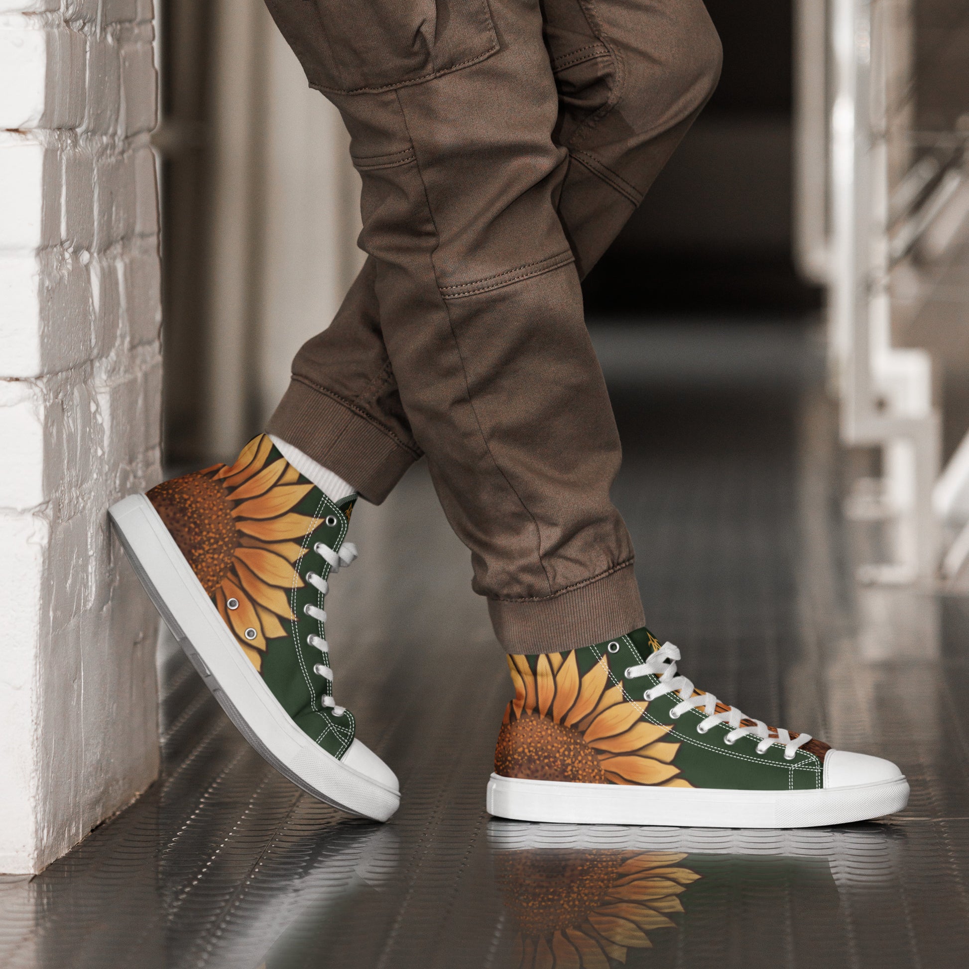 A model wears a pair of high top shoes with a large sunflower on the heel and a forest green background.