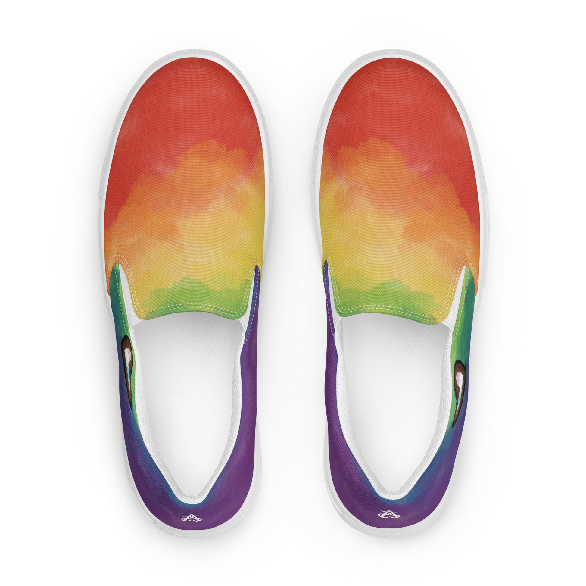 Top view: A pair of slip on shoes with rainbow clouds wrapping around the shoe, a double heart in black and brown with the trans pride flag inside, and the Aras Sivad Studio logo on the back of the heel.