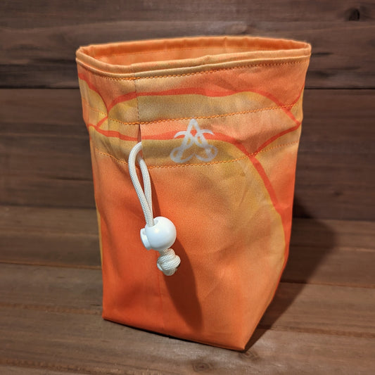 A drawstring bag with large watercolor tulip petals in shades of yellow and peach, orange stitching, and a matching tonal liner.