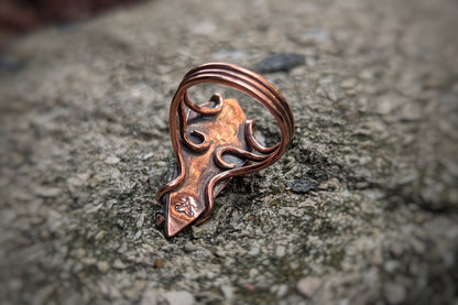 The back of the copper ring, showing the three wires that make up the ring shank splitting and spiraling to wrap around the backplate and form prongs.