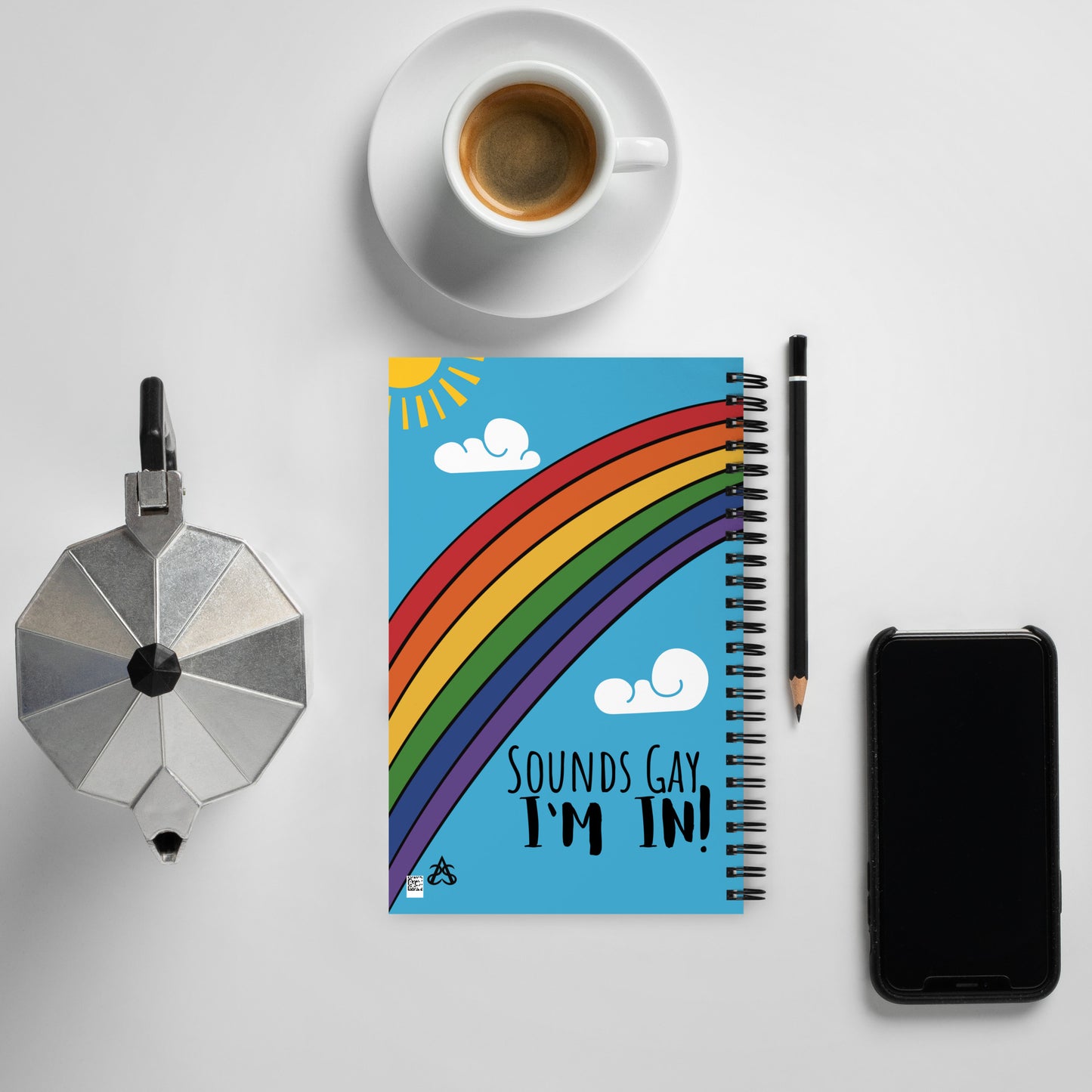 The back of spiral notebook with a bright rainbow across the front, a sun in the corner, the Aras Sivad logo in another corner, and clouds in the sky has bold writing that says, "Sounds Gay, I'm in!"