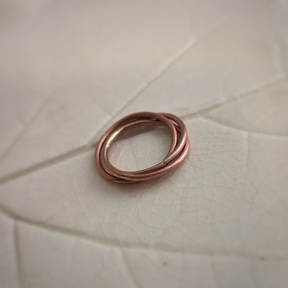 Three copper rings are entwined and soldered shut as one ring.