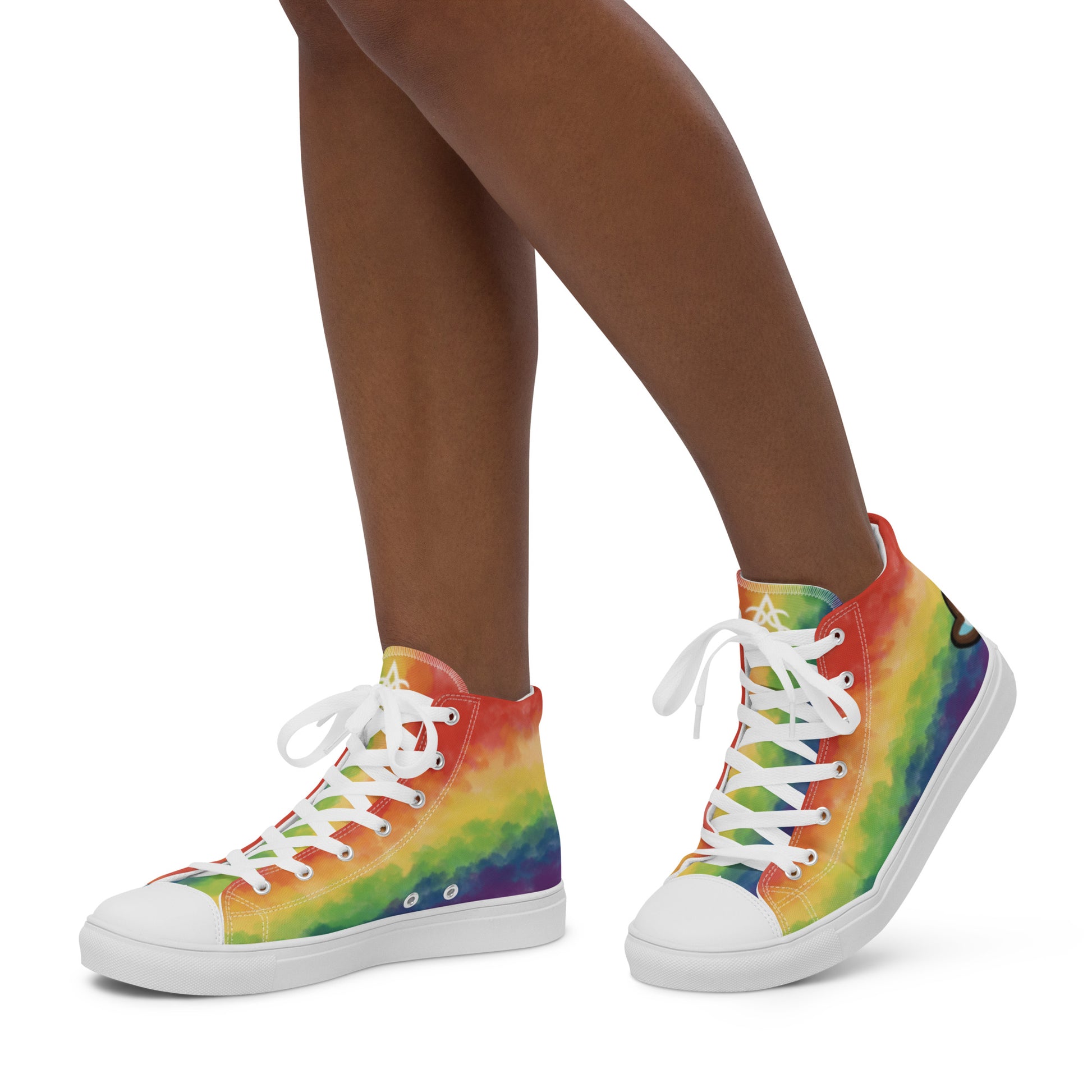 A model wears a pair of high top shoes with rainbow striped clouds on the sides and a double heart in black and brown with the trans flag colors inside.