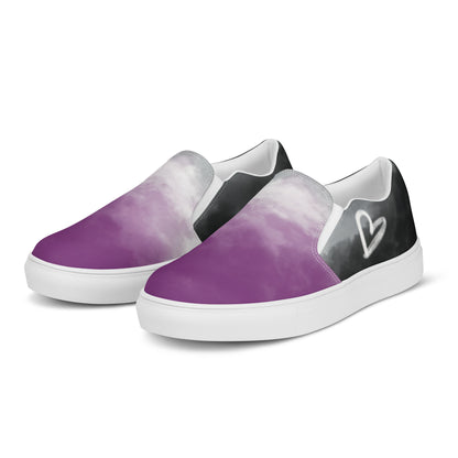 Left front view: A pair of slip-on shoes with clouds in the asexual flag colors, a hand drawn white heart on the side, and the Aras Sivad Studio logo on the back.