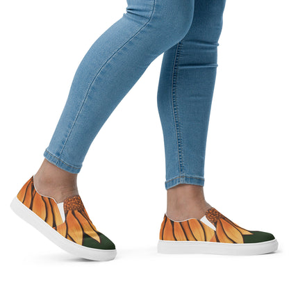A model wears slip on shoes that have the painted petals of a sunflower seeming to grow from their ankle.