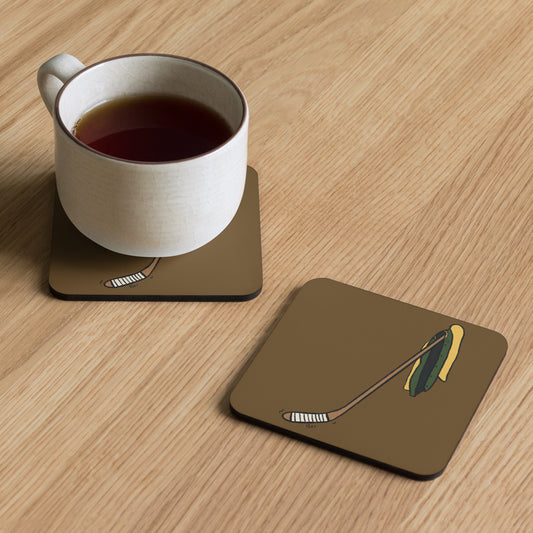 A pair of coasters sit on a table, one holding a mug of liquid, illustrated by Aras Sivad with a hockey stick and a yellow and green letterman jacket hanging on it.
