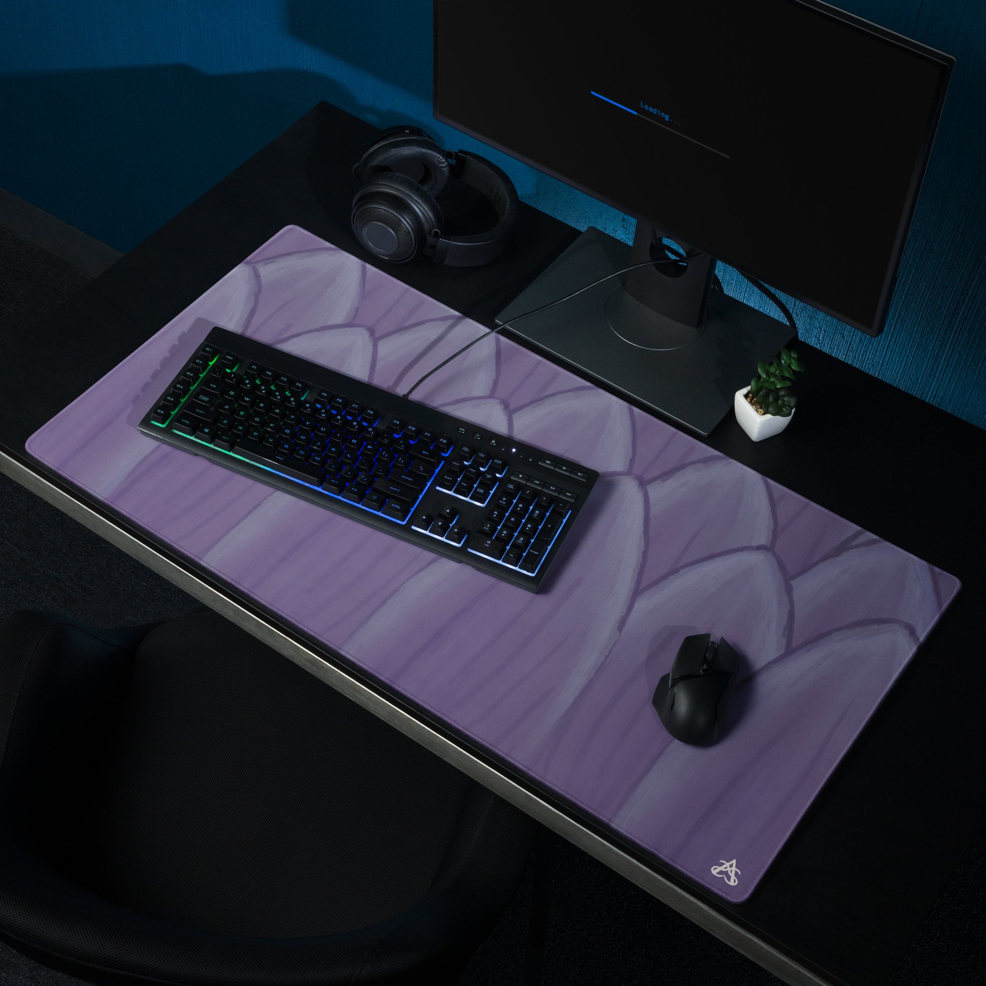 A computer set up with a lavender colored desk mat painted to look like lotus petals.