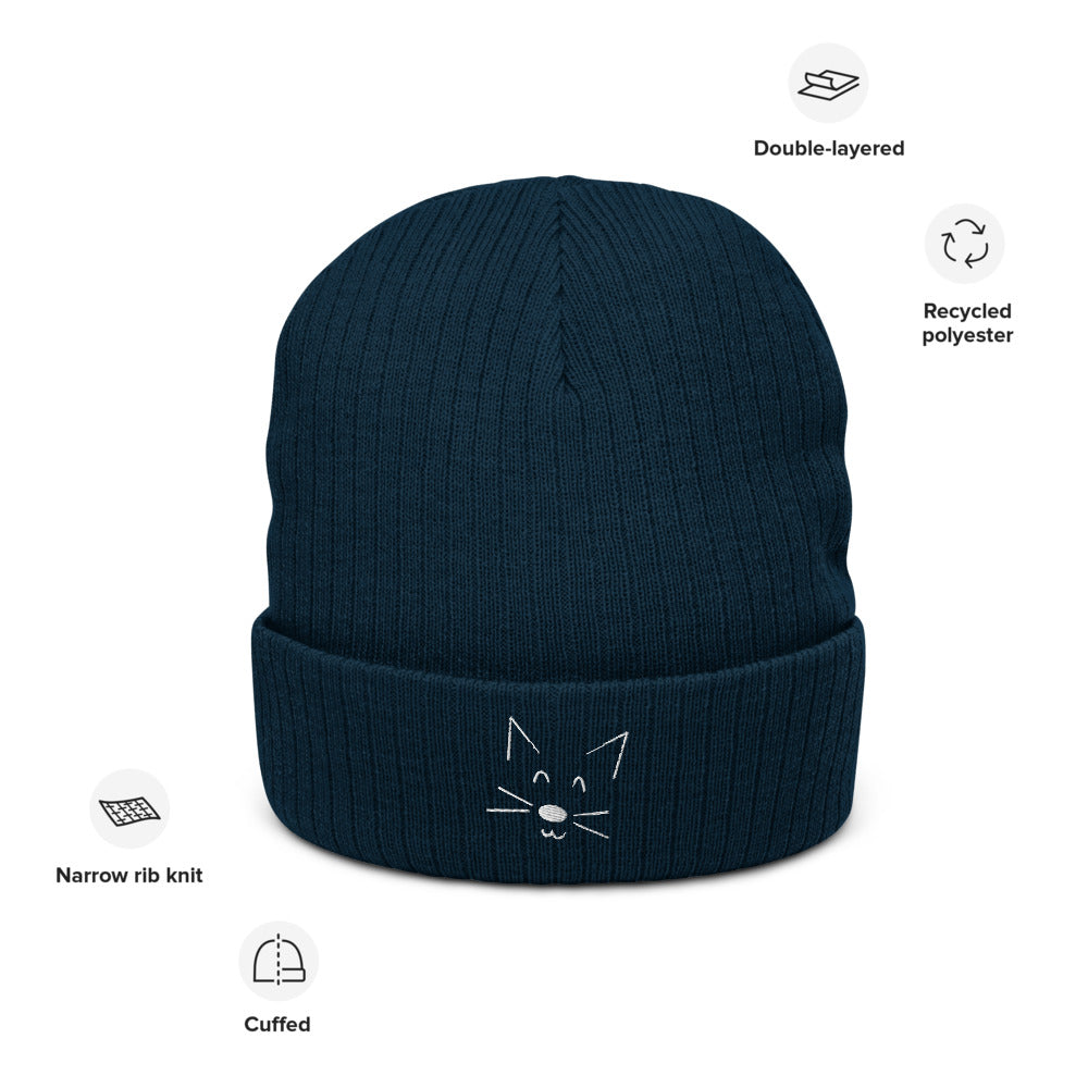 A picture of the blue rib knit beanie with a white cat face doodle detail on the cuff. Pictures around show features as listed in the main listing.